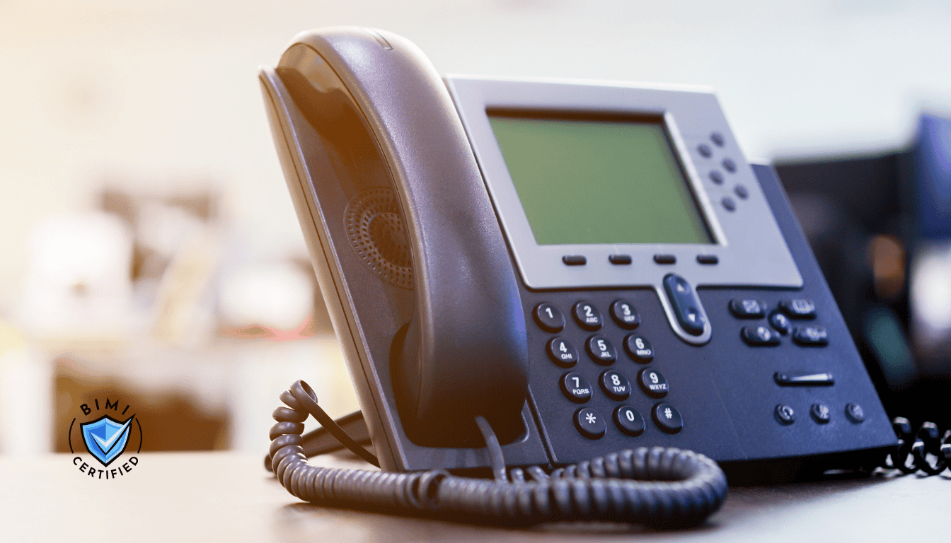 Moderný telefón na stole čakajúci na overovací hovor BIMI